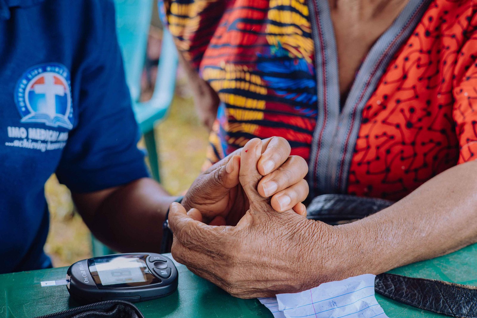 Christian medical mission outreach doctor checking blood pressure of an elderly patient